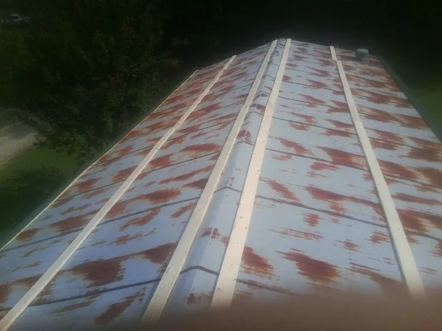 Rusted metal roof panels with new wood purlins before replacement — Storm Damage Roof Repair in Ludlow by Roofing Brothers