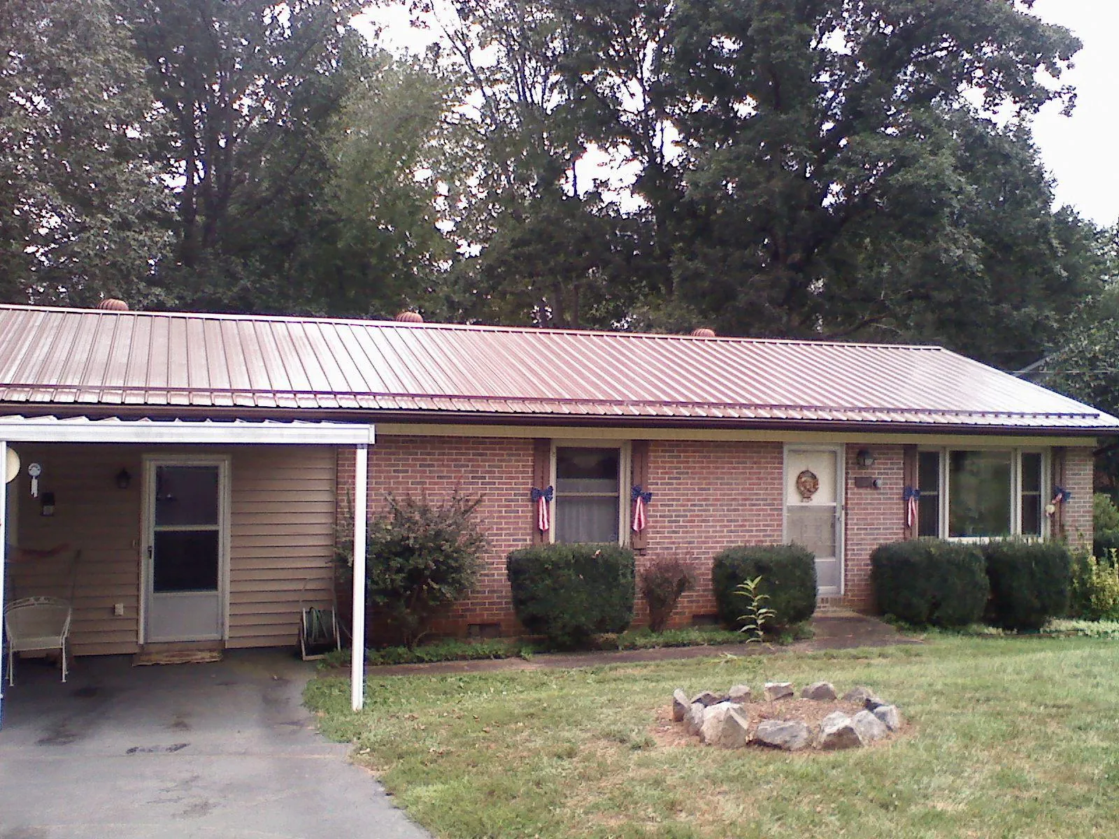 Bronze metal roof and carport on a brick ranch home — Roof Repair work by our crew in Ludlow